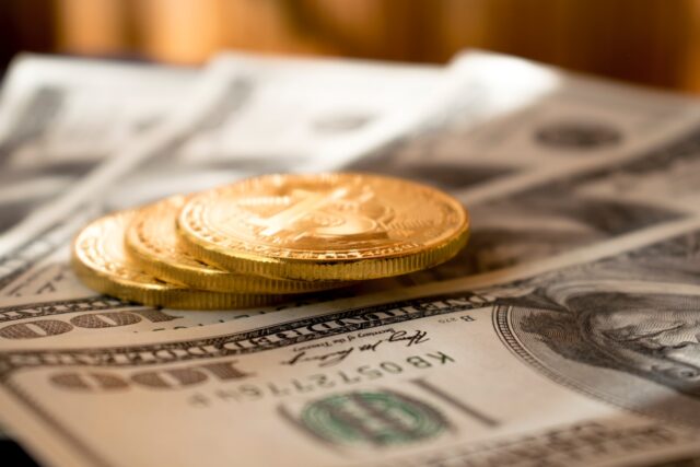 Photo by Dmitry Demidko three round gold-colored coins on 100 US dollar banknotes