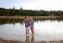 From Casual to Committed: The Journey of Relationships on Dating Platforms Couple Wearing Grey T-shirts Walking on Shallow Water and Smiling