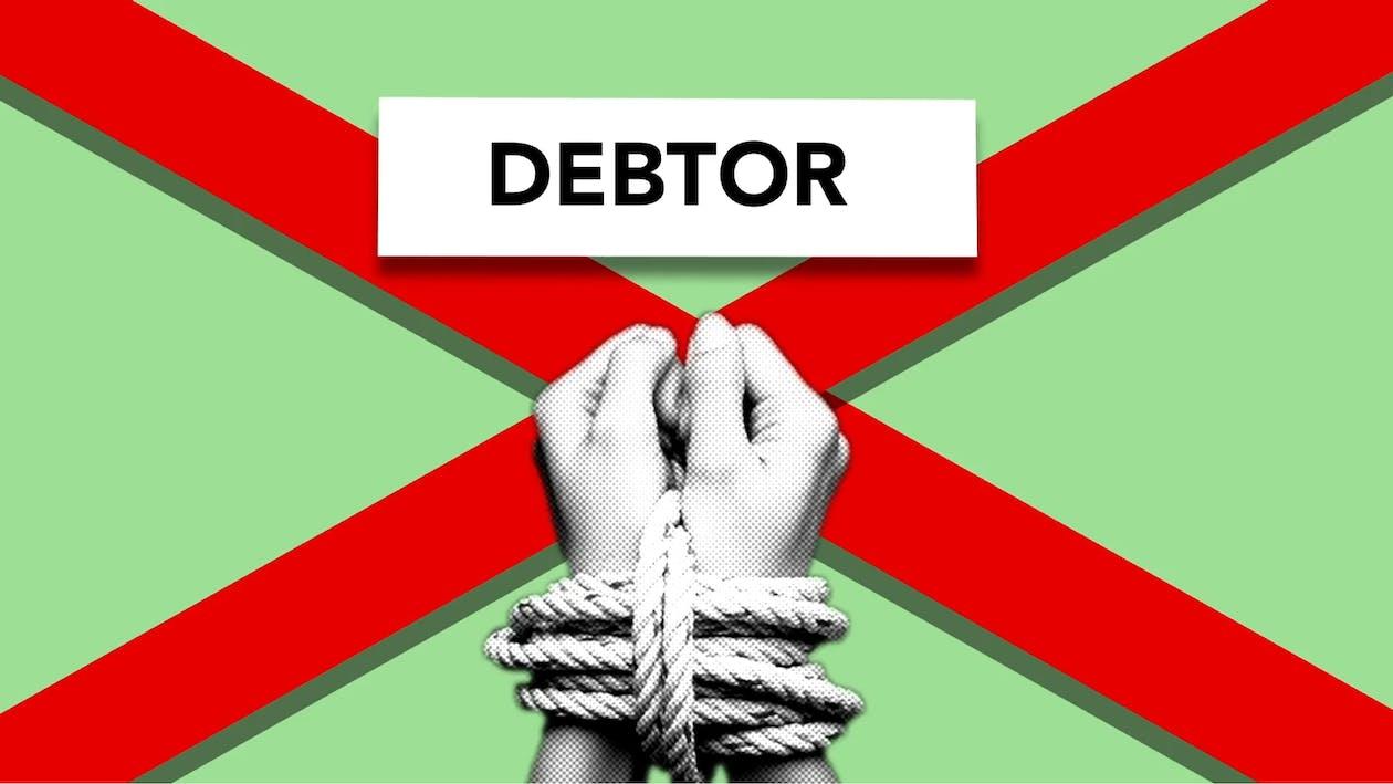 Free Illustration of debtor with hands tied with rope against cross symbolizing dependence on credit against green background Stock Photo