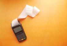 Tips for Catching Up Past Due Bills a cell phone sitting on top of a table next to a roll of paper