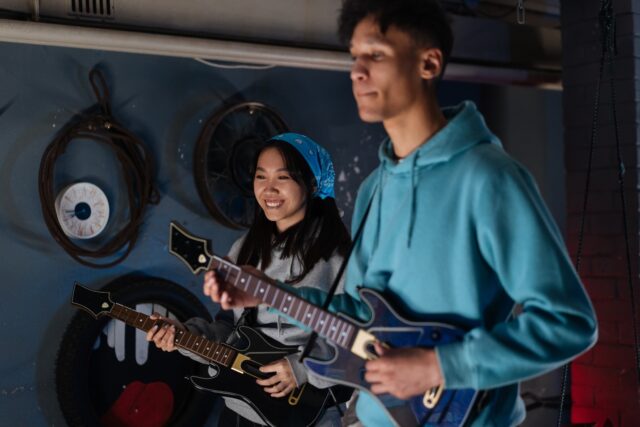 a-person-and-person-playing-guitars-description-a A person and person playing guitars Description automatically generated