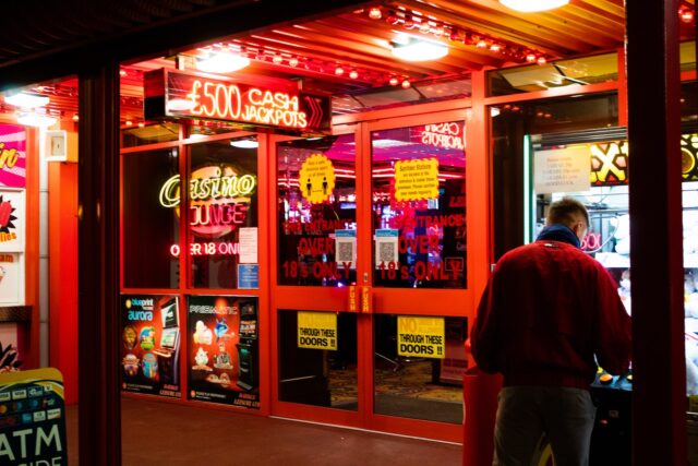 Photo by ben frost man in red shirt standing near store