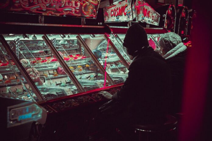 Photo by Carl Raw person playing on arcade machine