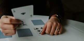 What Can a Professional Card Dealer Do person holding playing cards on white table