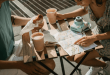 Beyond Bangers and Mash – A Brit’s Guide to Unexpectedly Excellent Eats A group of people sitting at a table with a map and drinks Description automatically generated