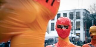 Rethinking the Use of Sexual Assault as a Cheap Punchline in Comedy man in orange crew neck shirt