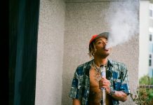 What a Bong Says About Your Stoner Priorities a man smoking a cigarette next to a potted plant