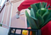 Home Security Tips to Help Protect Your Physical and Digital Lives—What Actually Works? Close-up of a person using a security keypad on a gate, highlighting home access control.