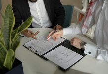 Settlement Calculator vs Lawyer: When to Use Each for Maximum Compensation two men sitting at a table with papers and a pen