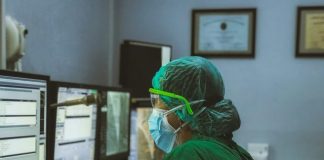 Inside The Hospital Ordering Department That Keeps Modern Care Running Smoothly person in green shirt wearing white mask