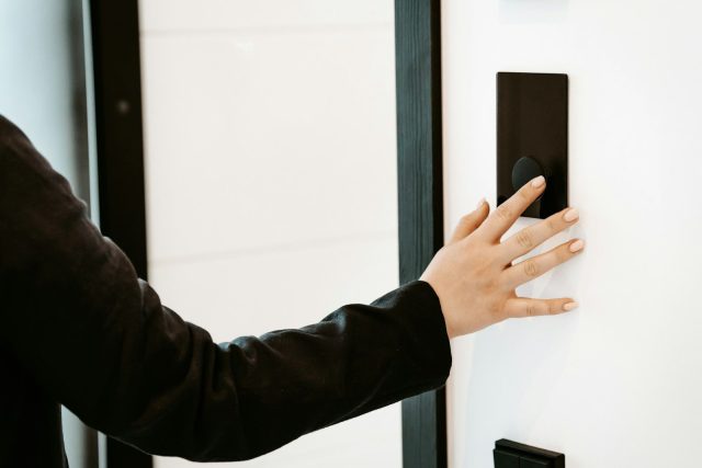 Photo by HUUM a person is pressing a button on a white wall